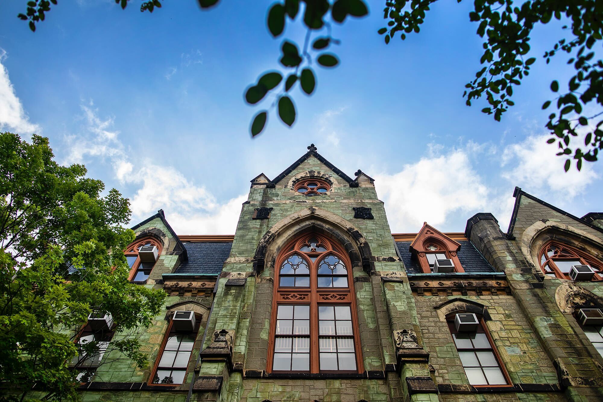 College Hall facade showing mature trees and collegiate gothic style architecture