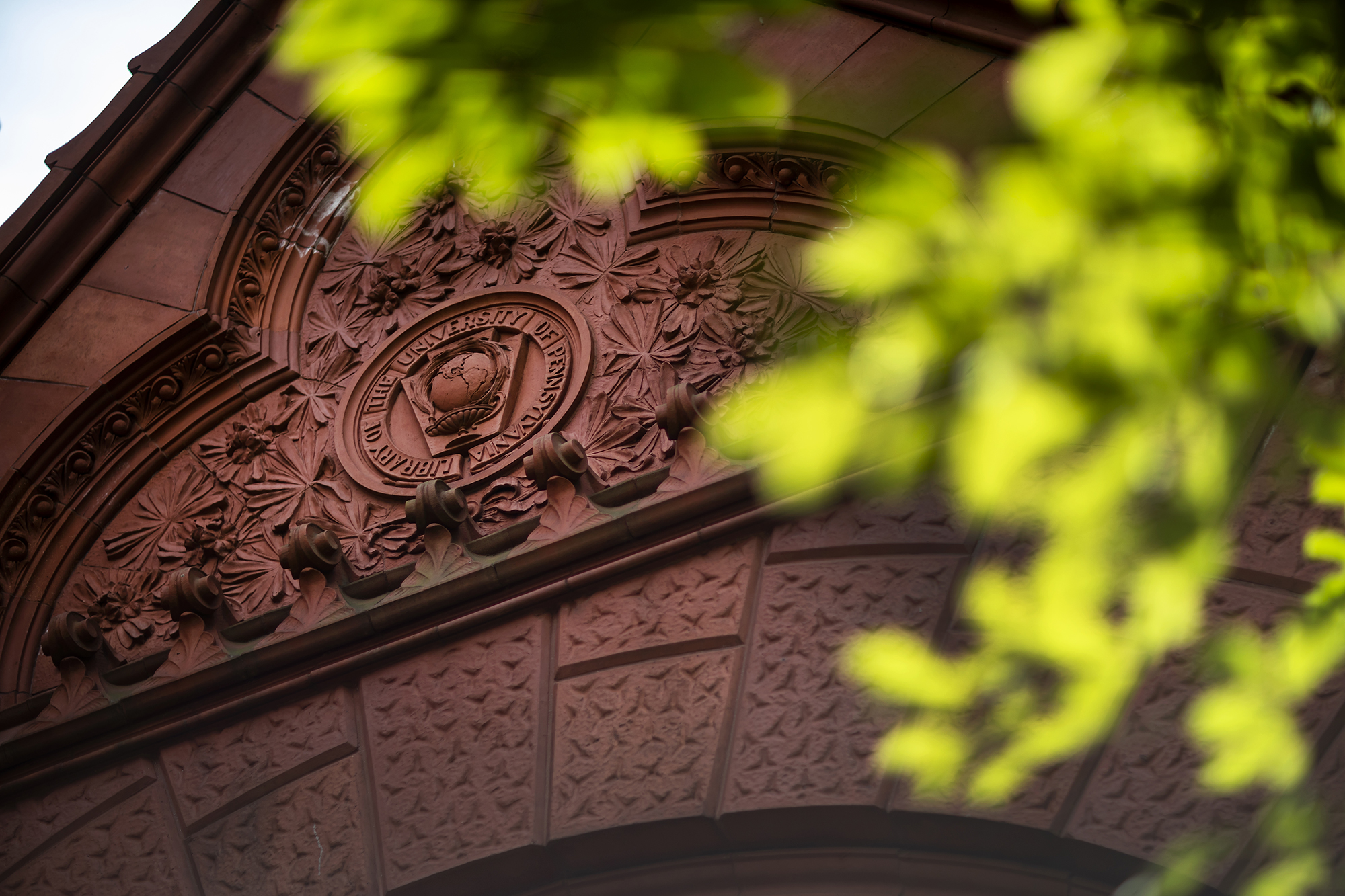 An early version of the University seal rendered in terracotta above the entrance to the Fisher Fine Arts Library